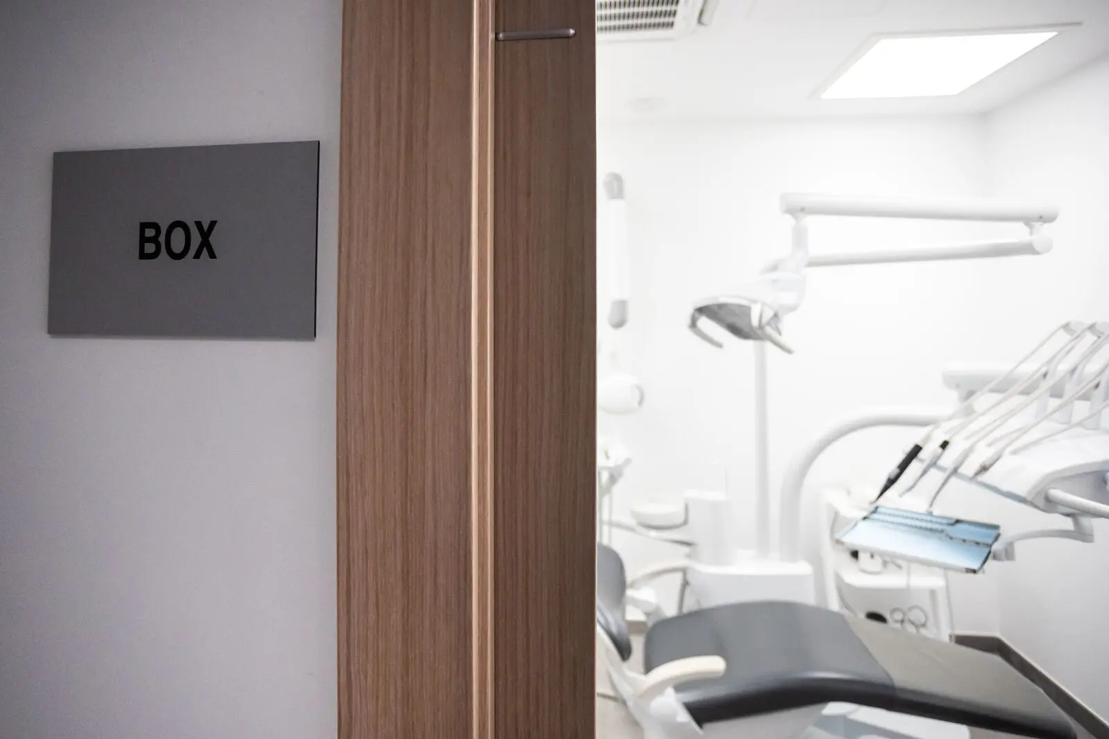 Puerta del box de la clínica, con el sillón dental al fondo